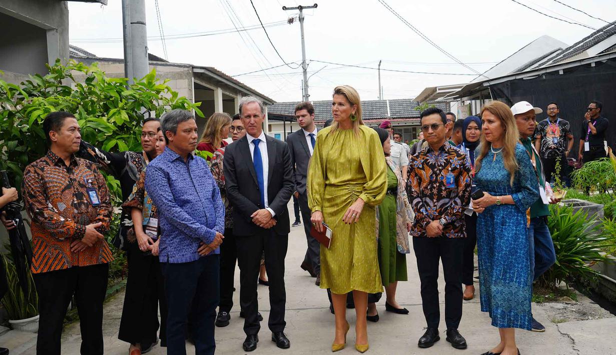 Saat berkunjung, Ratu Maxima menyempatkan untuk berinteraksi dengan warga penghuni kompleks perumahan bersubsidi tersebut. Tampak dalam foto, Ratu Maxima dari Belanda (tengah), dalam kapasitasnya sebagai Advokat Khusus Sekretaris Jenderal Perserikatan Bangsa Bangsa (PBB) untuk Kesehatan Keuangan (UNSGSA), mengunjungi kompleks perumahan bersubsidi untuk keluarga berpenghasilan rendah di Bekasi, Jawa Barat, pada Rabu 26 November 2025. (Tatan Syuflana/POOL/AFP)