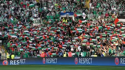 Para suporter Celtic mengibarkan bendera Palestina saat melawan Hapoel Beer Sheva asal Israel di babak kualifikasi play off Liga Champions di Celtic park, (19/8).  Aksi ini juga untuk mendukung kemerdakaan Palestina. (REUTERS/Russell Cheyne)