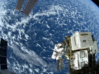 Astronot NASA Reid Wiseman saat bekerja di Stasiun luar angkasa Quest airlock dalam ekspedisi 41 awak di  Stasiun Luar Angkasa Internasional, (08/10/2014). Stasiun Luar Angkasa Internasional merayakan hari jadinya ke-15. (REUTERS/NASA)