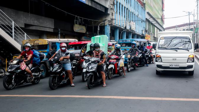 Pengendara motor mengenakan masker di Manila, Filipina (2/8/2020). Departemen Kesehatan negara itu melaporkan total 5.032 kasus baru Covid-19 pada Minggu (2/8) tersebut merupakan rekor kasus harian tertinggi selama empat hari berturut-turut. (Xinhua/Rouelle Umali)