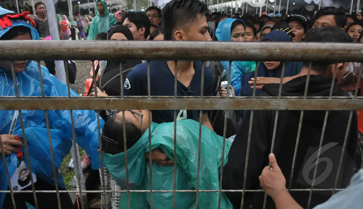Sejumlah wanita pingsan saat mengantre untuk menonton konser One Direction, Senayan, Jakarta, Rabu (25/3/2015). Puluhan ribu orang rela mengantre untuk melihat konser One Direction. (Liputan6.com/Johan Tallo)