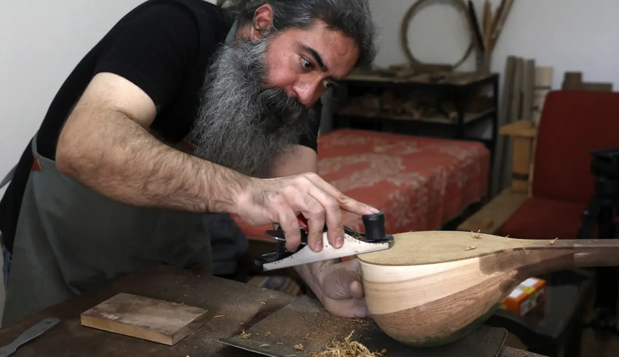 Luthier Ali Akbar Soleimani menyelesaikan pembuatan alat musik petik bernama Setar di bengkel kerjanya di Teheran, Iran pada 28 Januari 2021. Setar adalah sebuah alat musik Iran yang merupakan anggota keluarga kecapi. (AP Photo/Vahid Salemi)