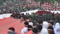 Anggota TNI POLRI  bersama warga masyarakat membawa bendera raksasa berukuran panjang 117 meter dan lebar 5 meter saat gelaran Festival Merah-Putih (FMP) 2018 di kawasan Air Mancur, Bogor ,  Minggu (5/8). (Merdeka.com/Arie Basuki)