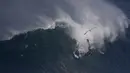 Aksi pesalancar Kealii Mamala menaklukan ombak di Praia do Norte, Nazare, Portugal, (13/11). Nazare Canyon memiliki kedalaman lebih dari 3 mil di bawah permukaan sehingga mampu menaikkan gelombang setinggi 100 sampai 150 kaki. (REUTERS/Rafael Marchante)