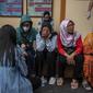 Keluarga dan kerabat korban tragedi Stadion Kanjuruhan menunggu di luar sebuah rumah sakit di Malang, Jawa Timur pada 2 Oktober 2022. Sedikitnya 174 orang tewas di stadion sepak bola Indonesia ketika ribuan penggemar tuan rumah yang marah menyerbu lapangan dan polisi menanggapi dengan gas air mata yang memicu desak-desakan, kata pihak berwenang pada 2 Oktober. (AFP/Juni Kriswanto)