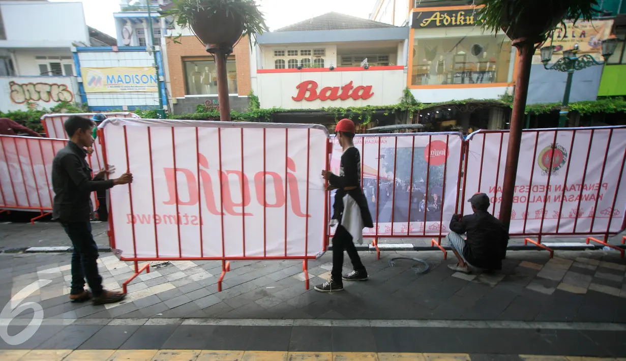 Sejumlah pekerja memasang pagar pembatas di kawasan pedestrian Malioboro, Senin (4/4). Terhitung sejak 4 April, kawasan Malioboro bebas dari parkir yang direlokasi ke Taman Parkir Abu Bakar Ali. (Liputan6.com/Boy Harjanto)