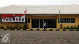 Seorang laki-laki melintasi salah satu gedung di areal DPP Partai Golkar di Slipi, Jakarta, Jumat (16/1/2016). Menurut salah satu petugas keamanan, sudah lebih kurang satu bulan terakhir tidak ada kegiatan di kantor ini. (Liputan6.com/Helmi Fithriansyah)