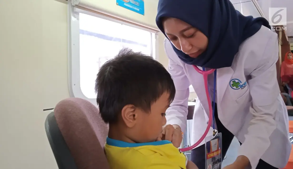 Petugas medis memeriksa seorang anak yang berobat ke Rail Clinic yang berhenti di Stasiun Alastua, Semarang, Jawa Tengah, Kamis ( 28/3). Pengobatan gratis dari PT KAI ini dihadiri oleh ratusan warga sekitar stasiun. (Liputan6.com/Gholib)