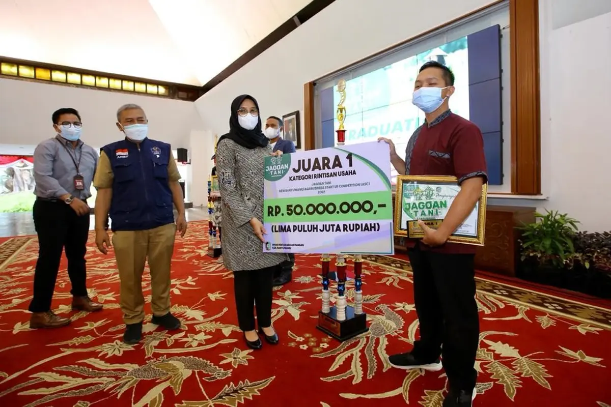 Bupati Banyuwangi Ipuk Fiestiandani menyerahkan hadian pada pemenang jagoan tani pada 2021. (Istimewa)