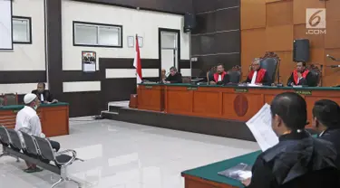 Terdakwa kasus penembakan dr Letty Sultri, dr Helmi mendengarkan dakwaan yang dibacakan oleh JPU di PN Jakarta Timur, Kamis (29/3). Helmi menjalani sidang perdana dengan agenda pembacaan surat dakwaan oleh JPU. (Liputan6.com/Herman Zakharia)