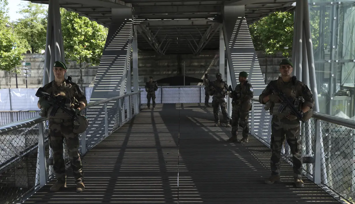 Tentara dan polisi Prancis dikerahkan di dalam dan di sepanjang Sungai Seine untuk mengamankannya selama upacara pembukaan Olimpiade Paris yang megah, ketika ribuan atlet akan berlayar menyusuri sungai saat matahari terbenam menuju Menara Eiffel. (AP Photo/Aurelien Morissard)