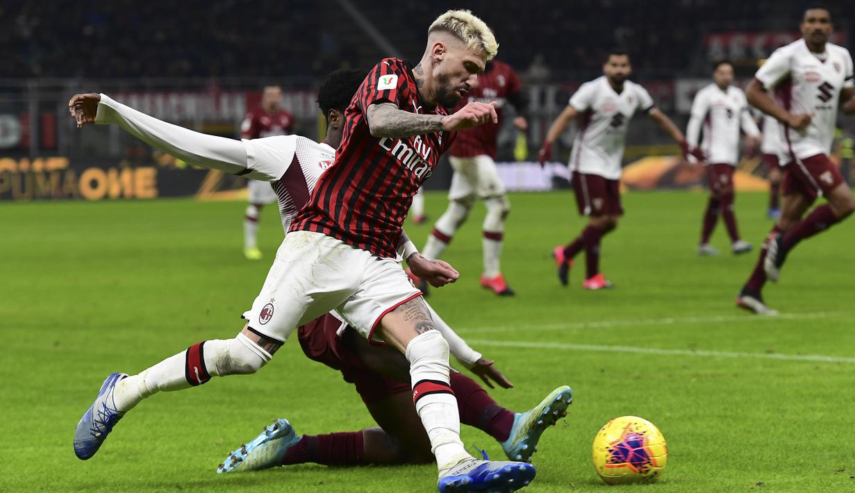 Striker AC Milan, Samu Castillejo, berusaha melewati bek Torino, Ola Aina, pada laga Coppa Italia di Stadion San Siro, Milan, Selasa (28/1). Milan menang 4-2 atas Torino. (AFP/Miguel Medina)
