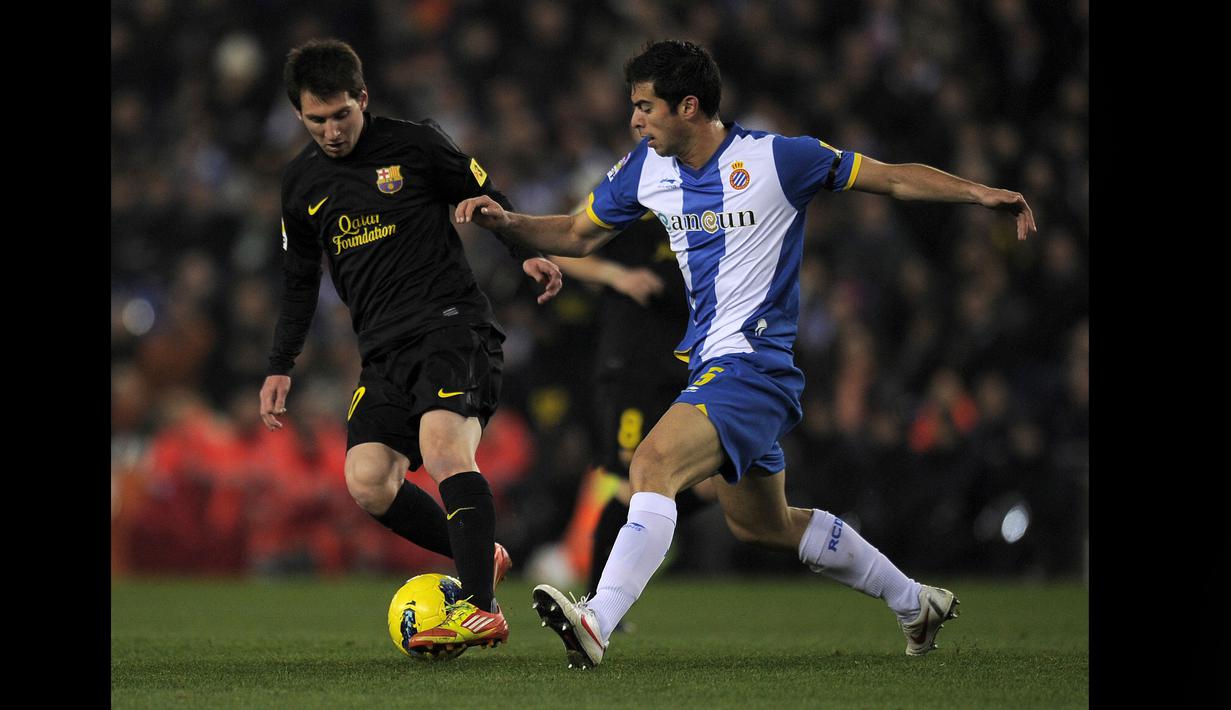 Pemain Espanyol, Jordi Amat (kanan), berusaha menghadang laju dari pemain Barcelona, Lionel Messi, dalam pertandingan lanjutan La Liga 2011/2012 yang berlangsung di stadion Cornella-El Prat , Minggu (8/1/2012). (AFP/Lluis Gene)