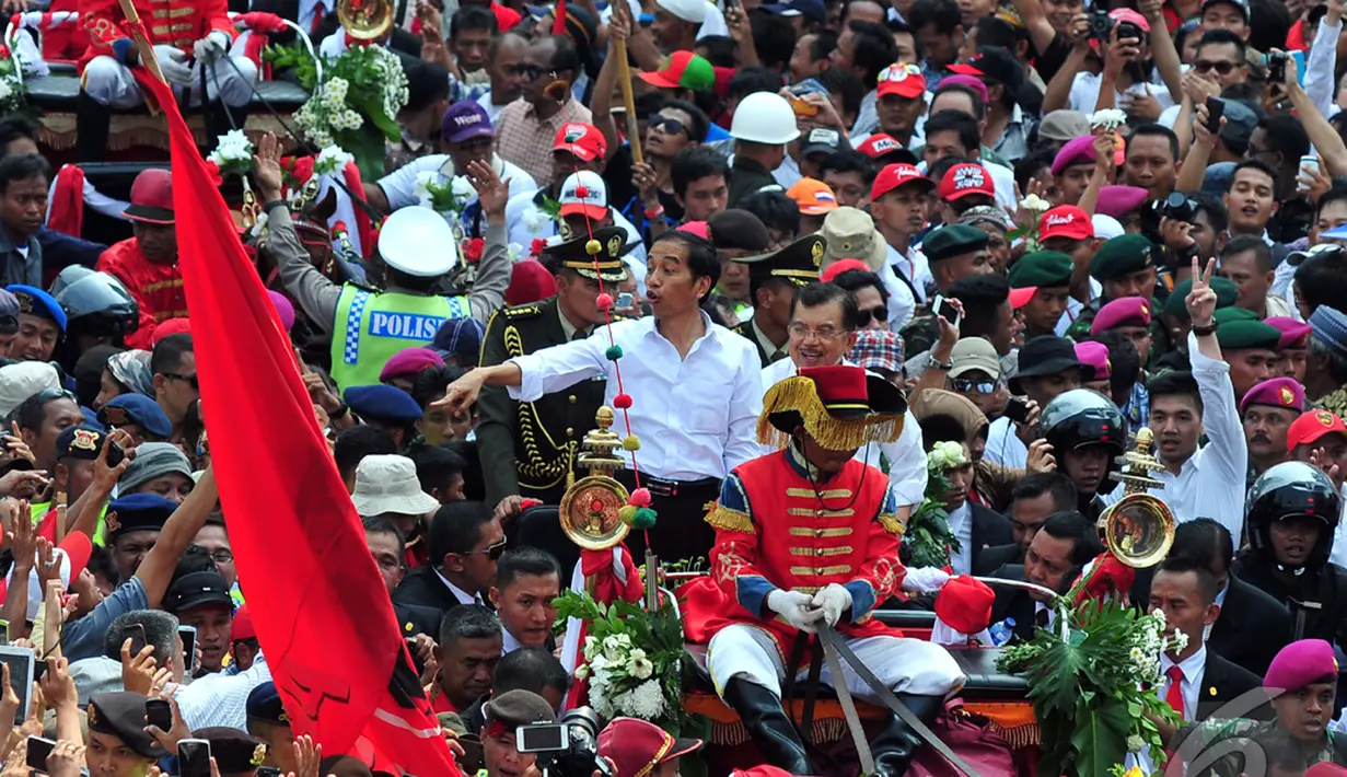 Melihat antusias rakyat yang menyambutnya, Jokowi hanya tersenyum dan melambaikan tangan, Jakarta, Senin (20/10/2014) (Liputan6.com/Johan Tallo)