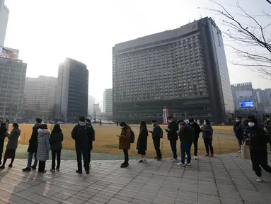 Orang-orang mengantre untuk tes virus corona COVID-19 sambil menjaga jarak sosial di klinik skrining sementara untuk virus corona dekat Balai Kota Seoul, Seoul, Korea Selatan, Rabu (26/1/2022). (AP Photo/Lee Jin-man)