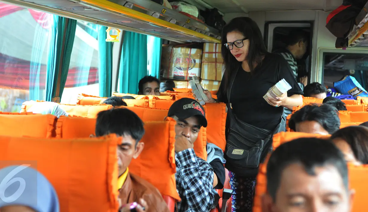 Penjual jasa penukaran uang sedang menawarkan pecahan uang kecil di dalam bus yang berada di Terminal Pulogadung, Jakarta, Jumat (10/7/2015). BI mengaku terus mewaspadai maraknya peredaran uang palsu menjelang Idul Fitri. (Liputan6.com/Herman Zakharia)