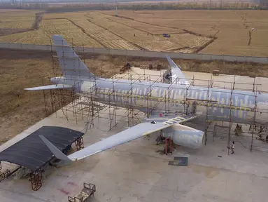 Foto udara memperlihatkan orang-orang menyelesaikan pembuatan replika pesawat Airbus A320 skala penuh di Kaiyuan, timur laut China, 25 Oktober 2018. Replika pesawat itu dibuat seorang petani, Zhu Yue yang merupakan penggemar dunia penerbangan. (STR/AFP)