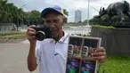 Fotografer taman, Joel Estrella berpose dengan kameranya di sebuah taman di Manila, Filipina (22/4). Estrella telah bekerja sebagai fotografer taman sejak tahun 1970. (AFP Photo/Ted Aljibe)