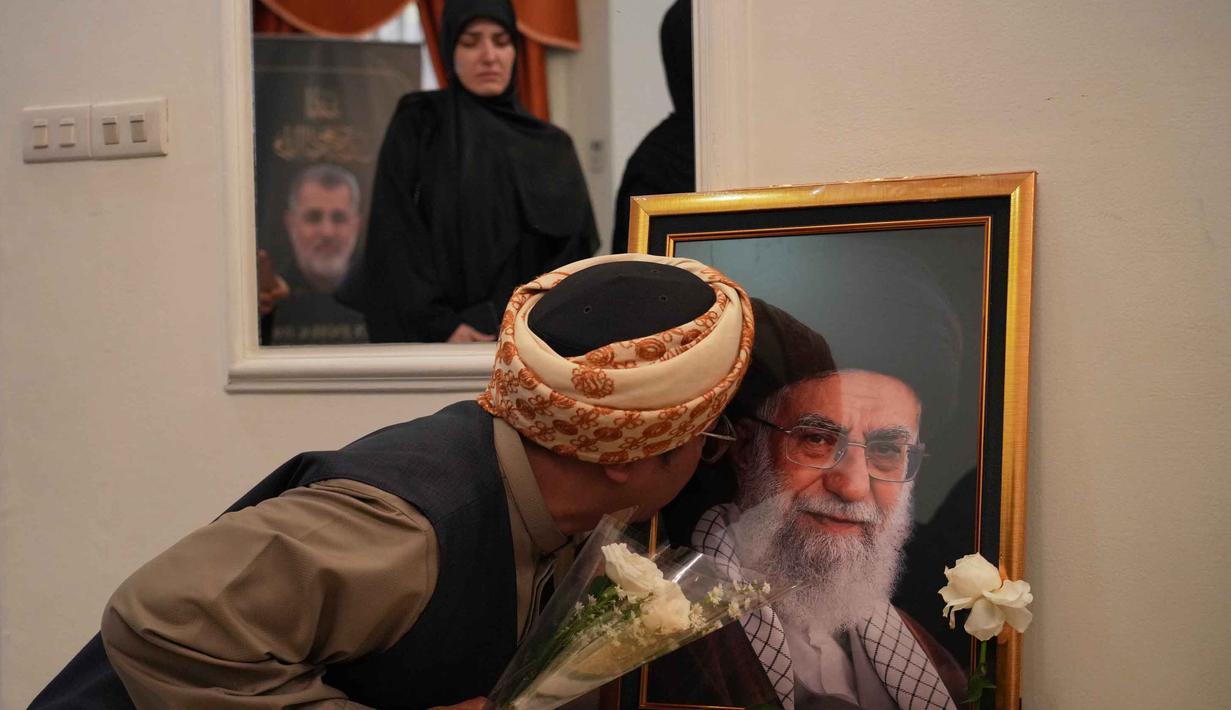 Melalui kegiatan ini, pihak kedutaan mengajak masyarakat internasional, termasuk Indonesia, untuk mendukung upaya perdamaian dunia serta mendorong penegakan nilai-nilai keadilan dan hukum internasional di tengah dinamika geopolitik yang berkembang. Tampak dalam foto, seorang pria mencium potret mendiang Pemimpin Tertinggi Iran Ayatollah Ali Khamenei di kediaman duta besar Iran untuk Indonesia, Jakarta, Kamis 5 Maret 2026. (AP Photo/Tatan Syuflana)