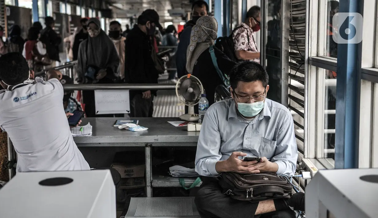 Calon penumpang mengoperasikan telepon genggam di Halte Harmoni, Jakarta, Senin (16/11/2020). Penyediaan fasilitas wifi gratis di halte Transjakarta guna meningkatkan kenyamanan penumpang. (merdeka.com/Iqbal S. Nugroho)