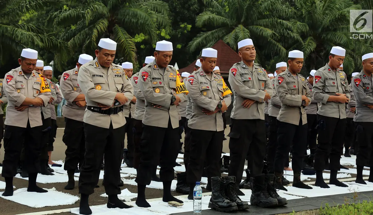 Personel Brimob yang tergabung dalam Pasukan Dzikir Asmaul Husna menjalankan salat di depan Gedung MPR/DPR, Senayan, Jakarta, Selasa (24/10). Sebanyak 299 personel dikerahkan untuk menjaga demo menolak Perppu Ormas di gedung DPR. (Liputan6.com/JohanTallo)