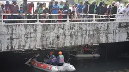 Warga berkerumun melihat upaya tim gabungan Damkar, BPBD, dan KLHK melakukan pencarian buaya di Kali Grogol, Jakarta Barat, Kamis (28/6). Satwa yang tergolong buas tersebut dikhawatirkan mengancam keselamatan. (Merdeka.com/Iqbal S. Nugroho)