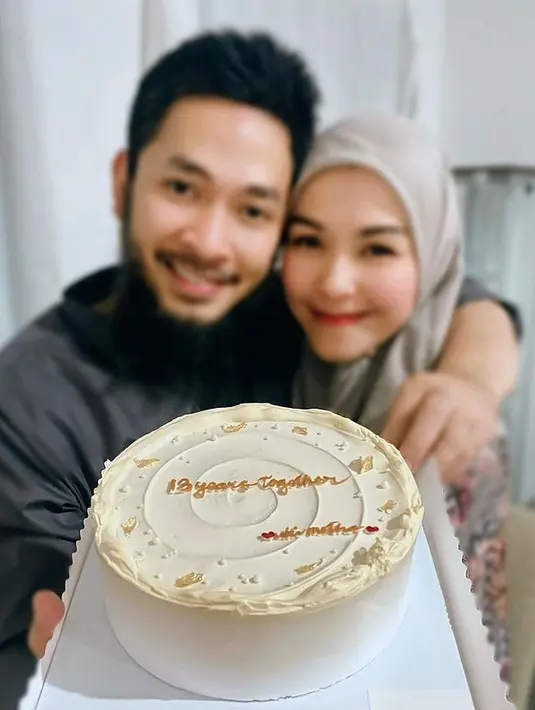 Lewat media sosial Metha mengunggah potret dirinya dan Uki yang tengah memegang sebuah cake, merayakan pernikahan mereka. (Foto: Instagram/methayuna)