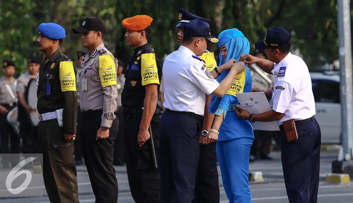 Ignasius Jonan memakaikan tanda di lengan secara simbolis saat apel siaga arus mudik Lebaran 2015, Jakarta, Kamis (2/7/2015). Jonan mengingatkan otoritas yang bertugas agar memberikan pelayanan terbaik kepada para pemudik. (Liputan6.com/Faizal Fanani)