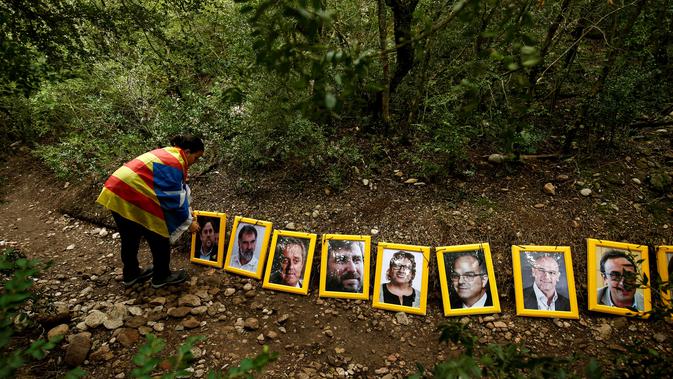 Sejumlah potret orang-orang yang dipenjara dan diasingkan karena mendukung presiden terguling Catalonia, Carles Puigdemont dijejerkan setelah dibawa ke Gunung Montserrat, Spanyol (28/4). (AFP/Pau Barrena)