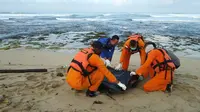 Petugas Basarnas tengah mengevekuasi salah satu korban tenggelam di pantai Cijeruk, Cibalong Garut  (Liputan6.com/Jayadi Supriadin)