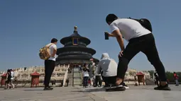 Orang-orang berjalan dalam Kuil Surga saat liburan Hari Buruh di Beijing, China, 2 Mei 2022. Hari Buruh pada umumnya dirayakan pada tanggal 1 Mei, dan dikenal dengan sebutan May Day. (Noel Celis/AFP)