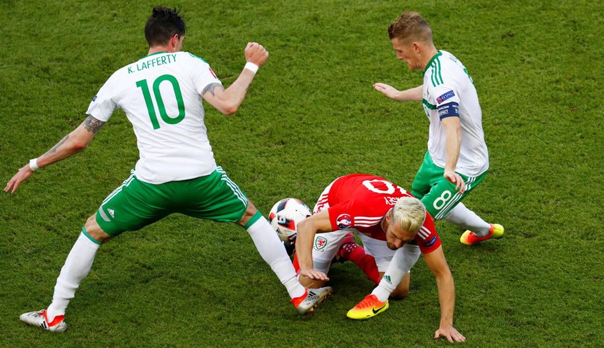 Pergerakan pemain Wales, Aaron Ramsey, dihadang dua pemain Irlandia Utara pada laga 16 besar Piala Eropa 2016 di Parc des Princes, Paris, Sabtu (25/6/2016) malam WIB. (Reuters/Christian Hartmann)