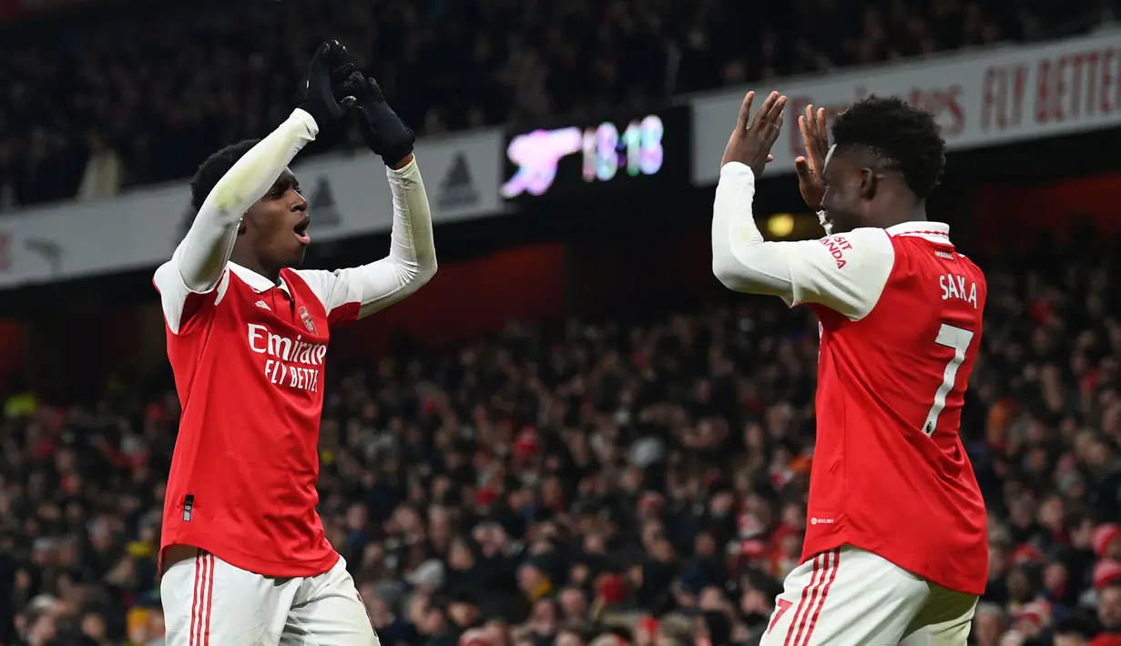 Pemain Arsenal, Eddie Nketiah melakukan selebrasi bersama rekannya, Bukayo Saka setelah mencetak gol ketiga timnya ke gawang Manchester United pada laga lanjutan Liga Inggris 2022/2023 yang berlangsung di Emirates Satdium, London, Minggu (23/01/2023). Arsenal berhasil menang dengan skor 3-2 atas Manchester United. (AFP/Glyn Kirk)