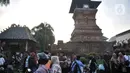 Peziarah bersantai di dekat Menara Kudus, Kauman, Kabupaten Kudus, Jawa Tengah, Rabu (30/3/2022). Menara berusia 473 tahun yang dahulu berfungsi sebagai tempat mengumandangkan azan menjadi lokasi favorit pengunjung untuk bersantai usai berziarah di Makam Sunan Kudus. (merdeka.com/Iqbal S. Nugroho)