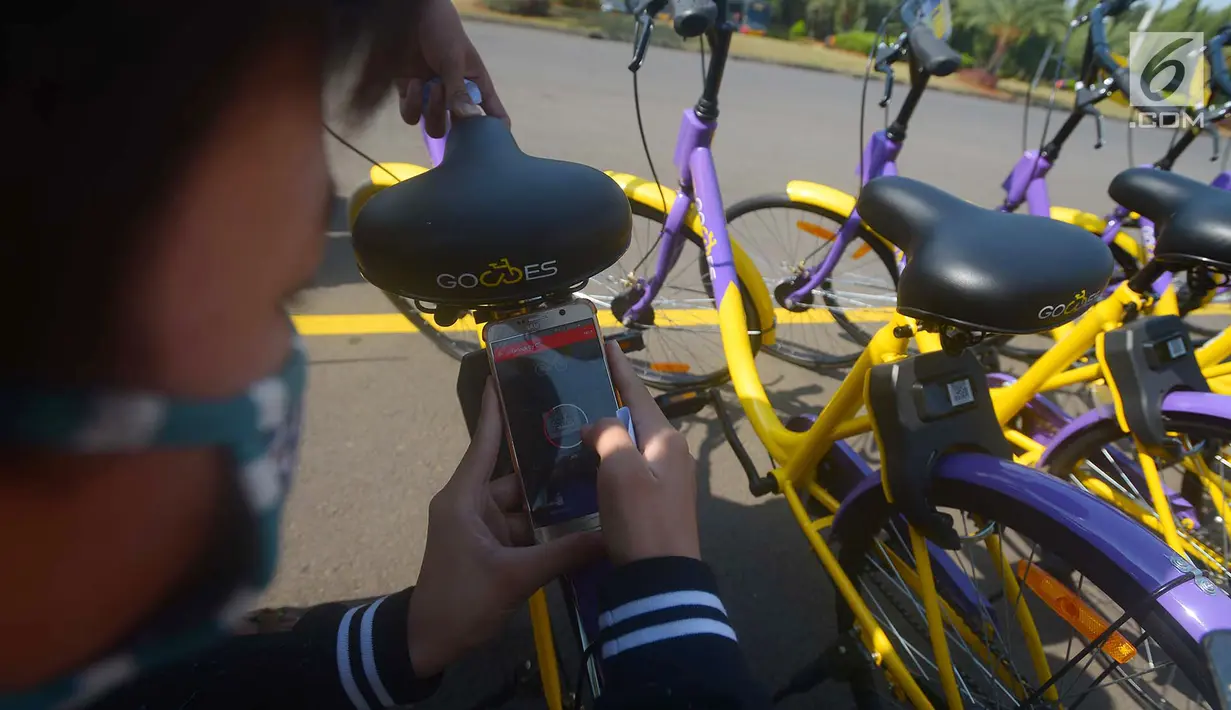 Pengunjung menscan QR Code untuk bisa menggunakan sepeda dari layanan bike sharing di Monas, Jakarta, Jumat (27/7). Ada 100 sepeda yang bisa diakses di tujuh titik di dalam Monas. (Merdeka.com/Imam Buhori)