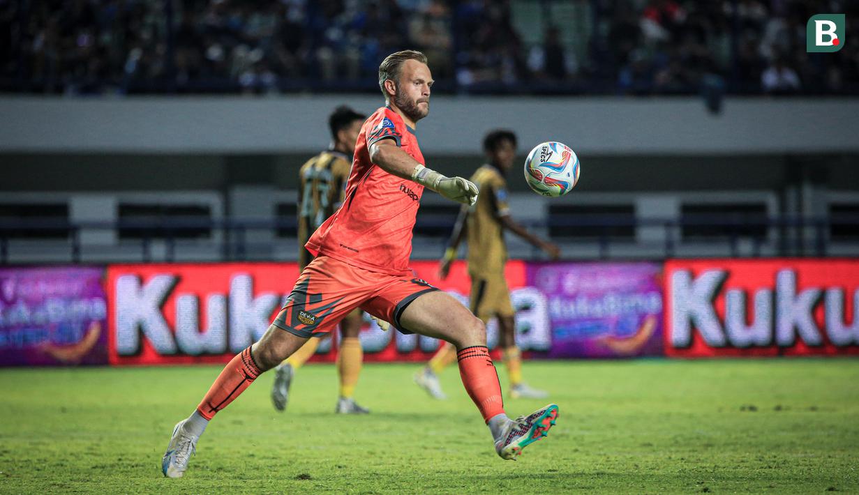 Kiper Dewa United, Sonny Stevens menendang bola pada laga pekan ketiga BRI Liga 1 2023/2024 antara Persib Bandung melawan Dewa United di Stadion GBLA, Bandung, Jumat (14/07/2023). (Bola.com/Bagaskara Lazuardi)