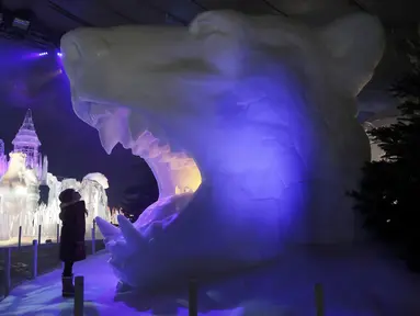 Seorang anak melihat patung es berbentuk kepala macan di kerajaan es Hyde Park Winter Wonderlands Magical Ice, London, Kamis (17/11). Hyde Park Winter Wonderlands Magical Ice dibuka untuk memeriahkan musim dingin di Inggris. (Reuters/stefan wermuth)