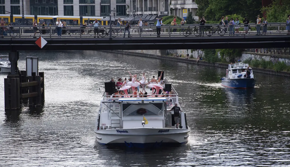 Anggota Staatsballett Berlin menari di atas kapal pesiar selama tur melalui pusat kota di Berlin, Jerman, Kamis (10/6/2021). Pertunjukan itu diikuti oleh banyak orang di sepanjang rute. (Paul Zinken/dpa via AP)
