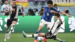 Pemain Timnas Jepang, Wataru Endo (tengah) berusaha melewati penjagaan pemain Timnas Jerman, Leon Goretzka pada laga Grup E Piala Dunia 2022 di Khalifa International Stadium, Doha, Qatar 23 November 2022. (AFP/Jewel Samad)