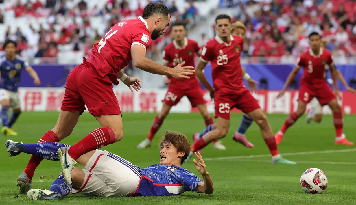 Striker Timnas Jepang, Ayase Ueda terjatuh usai dilanggar bek Indonesia, Jordi Amat di dalam kotak penalti pada laga ketiga Grup D Piala Asia 2024 di Al-Thumama Stadium, Doha, Qatar, Rabu (24/1/2024) malam WIB. (AFP/Giuseppe Cacace)