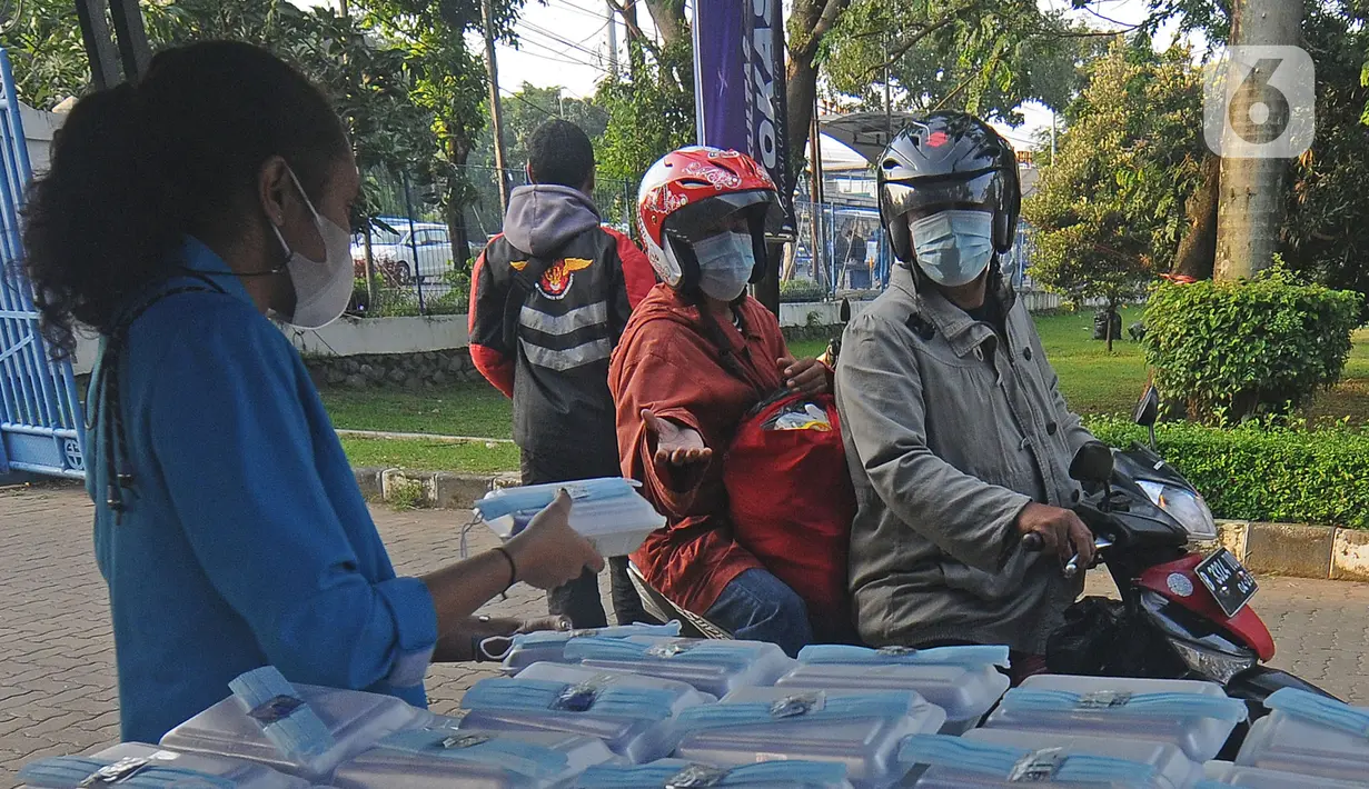 Mahasiswa memberikan makanan gratis kepada masyarakat di Universitas Kristen Indonesia (UKI), Cawang, Jakarta, Selasa (16/3/2021). Kegiatan berbagi makanan gratis yang dilakukan oleh civitas akademi UKI itu diselenggarakan selama tiga bulan. (Liputan6.com/Herman Zakharia)