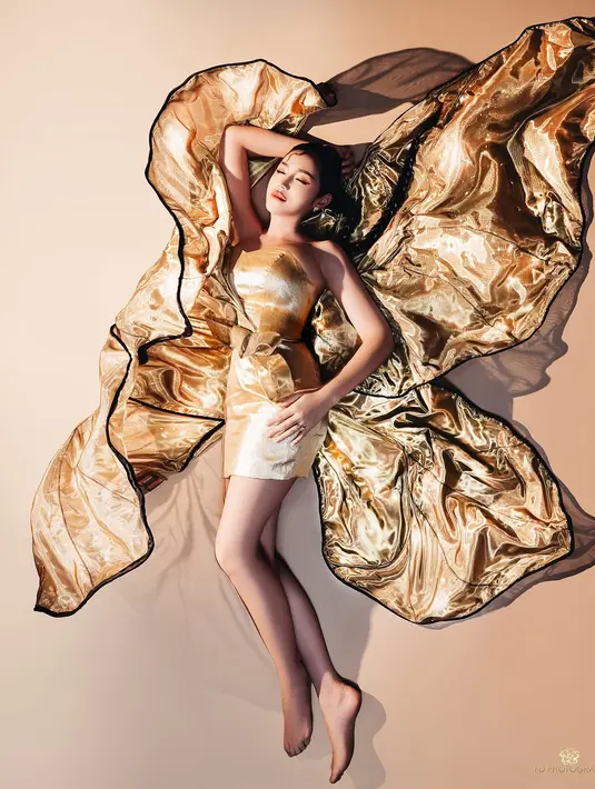 Ia kenakan strapless mini dress berpita dan aksen sayap kupu-kupu emas yang besar [@inijedar]