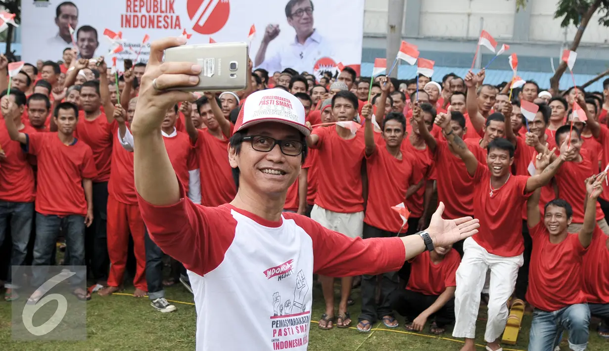 Komposer Adi MS berselfie bersama warga binaan Lapas Narkotika Cipinang menyanyikan lagu Hari Merdeka di LP Cipinang, Jakarta, Senin (15/8). Kegiatan bernyanyi secara serentak oleh 150 ribu peserta ini mencetak rekor MURI. (Liputan6.com/Yoppy Renato)