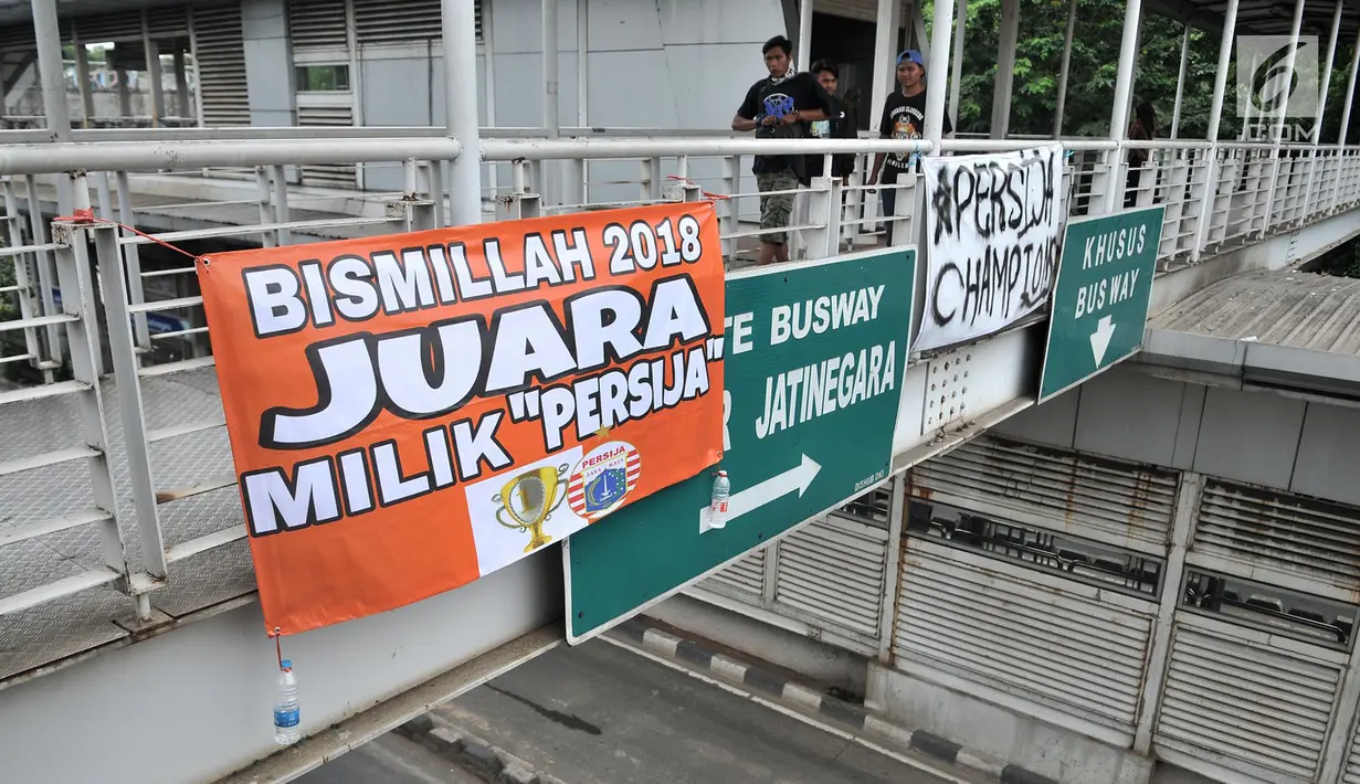 Spanduk dukungan Persija yang terpasang di JPO, Jakarta, Minggu (9/12). Jelang laga penentuan pekan ke-34 Liga 1 antara Persija melawan Mitra Kukar, spanduk dukungan juara The Jakmania bermunculan di JPO jalan Ibu Kota. (Merdeka.com/Iqbal S. Nugroho)