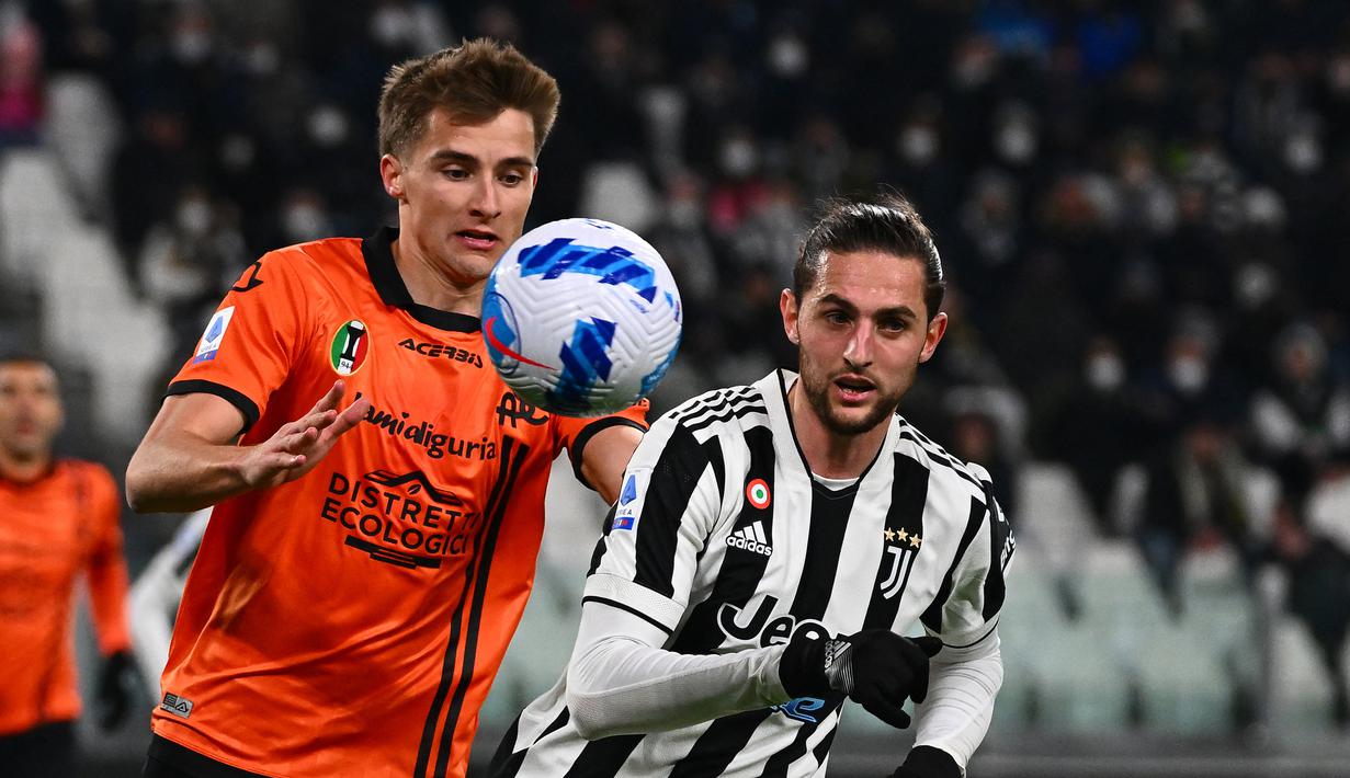 Bek Spezia Salvador Ferrer (kiri) berebut bola dengan gelandang Juventus Adrien Rabiot pada pertandingan Liga Italia pekan ke-28 di Allianz Stadium, Senin (7/3/2022) dini hari WIB. Juventus menang 1-0 atas Spezia lewat gol Alvaro Morata. (MIGUEL MEDINA / AFP)