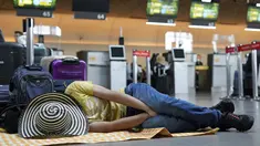 Seorang penumpang maskapai Viva Air tidur di bandara setelah maskapai berbiaya rendah itu menangguhkan operasinya di Bandara Internasional El Dorado di Bogota, Kolombia, Selasa (28/2/2023). Maskapai sedang menunggu penyelesaian proses integrasi dengan sekelompok maskapai penerbangan yang harus disetujui oleh otoritas Kolombia. (AP Photo/Fernando Vergara)