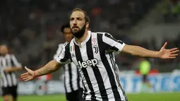 Striker Juventus, Gonzalo Higuain berselebrasi setelah mencetak gol ke gawang AC MIlan pada lanjutan Liga Italia di Stadion San Siro, Sabtu (28/10). Higuain memborong gol kemenangan saat Juventus mempermalukan Milan 2-0. (AP/Luca Bruno)