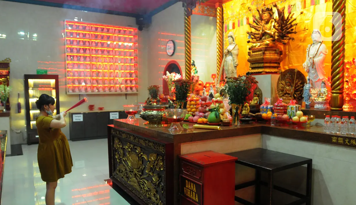 Warga Tionghoa memanjatkan doa sambil membawa hio (dupa) pada malam tahun baru Imlek 2573 di  Vihara Kwan In Thang, Pondok Cabe, Tangerang Selatan, Senin (31/1/2022). Perayaan malam Imlek berlangsung khidmat dan sederhana di tengah merebaknya covid-19 varian omicron. (merdeka.com/Arie Basuki)
