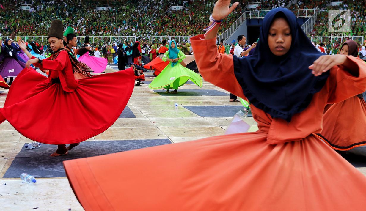 Penampilan penari sufi saat memeriahkan Harlah ke-73 Muslimat NU di SUGBK, Jakarta, Minggu (27/1). Penampilan 999 penari sufi ini mencetak rekor dunia. (Liputan6.com/JohanTallo)