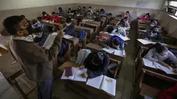 Suasana kegiatan belajar mengajar di kelas saat sekolah dibuka kembali setelah ditutup selama berbulan-bulan karena pandemi COVID-19 di Ahmedabad, India, Senin (11/1/2021). Negara bagian Gujarat telah membuka kembali sekolah hanya untuk kelas 10 dan 12. (AP Photo/Ajit Solanki)